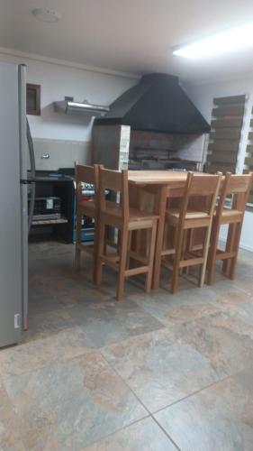 a kitchen with a wooden table and chairs at USHUAIA FOR´NS in Ushuaia