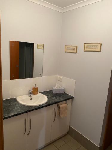 a bathroom with a sink and a mirror at Lazy Days Cottage - Victor Harbor in Hindmarsh Valley
