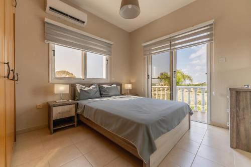 a bedroom with a bed and a large window at Villa Mespila_ Ayia Napa in Ayia Napa