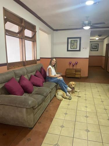 a woman sitting on a couch with a dog at Boutique Hotel Calle 20 in San José