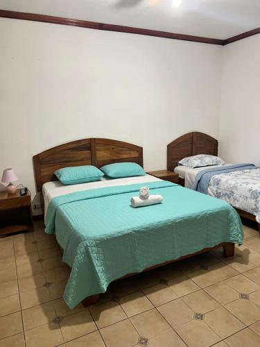 a bedroom with two beds with blue pillows at Boutique Hotel Calle 20 in San José