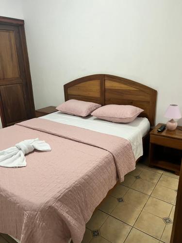 a bedroom with a bed with two towels on it at Boutique Hotel Calle 20 in San José