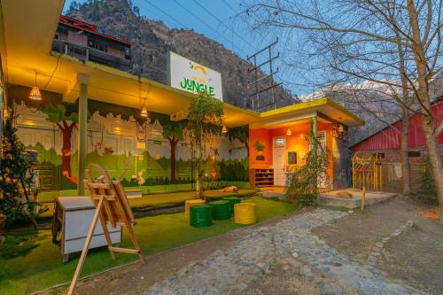 a house with a sign on the front of it at Jungle Hostel by Whoopers in Kasol
