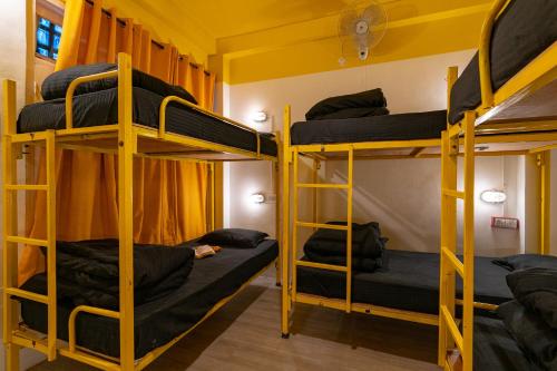 a bunk bed room with three bunk beds in it at Jungle Hostel by Whoopers in Kasol