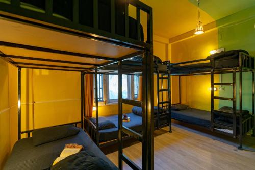 a room with three bunk beds and a couch at Jungle Hostel by Whoopers in Kasol