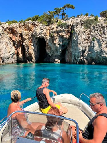 a group of people on a boat in front of a cave at TO VOTSALO-beach side studios & taverna in Karpathos Town