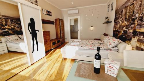 Parliament View Apartment في بودابست: غرفة معيشة مع أريكة بيضاء وزجاجة من النبيذ
