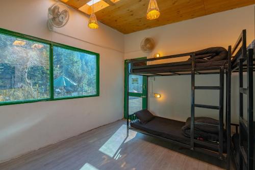 a room with a bunk bed and two windows at Jungle Hostel by Whoopers in Kasol