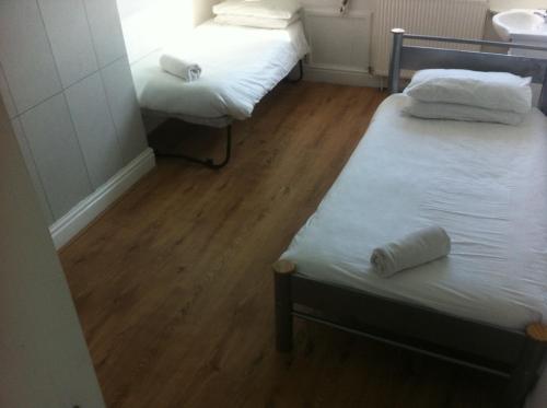 two twin beds in a room with wooden floors at Boscombe Reef Hotel in Bournemouth
