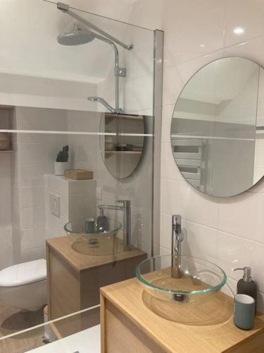 une salle de bain avec un lavabo et un miroir dans l'établissement T2 Super Cosy à la cîme des pins proche av de Gaulle avec place de parking, à La Baule