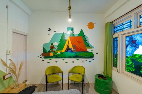 a room with two chairs and a tent on the wall at Jungle Hostel by Whoopers in Kasol