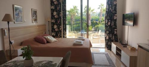 een slaapkamer met een bed en een groot raam bij Harmony Seaview Apartments in Paphos City