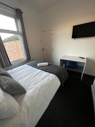 a bedroom with a bed and a desk and a window at Stylish Town House - Modern double room - 4 in Parkside