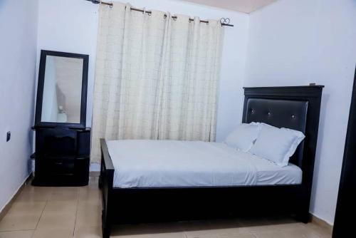 a bedroom with a bed and a mirror and a window at Ocean Breeze in Limbe