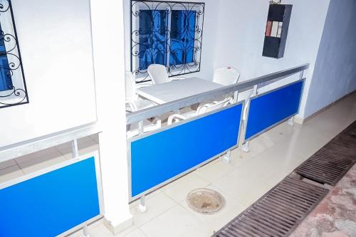 een badkamer met blauwe en witte wastafels en een spiegel bij Ocean Breeze in Limbe