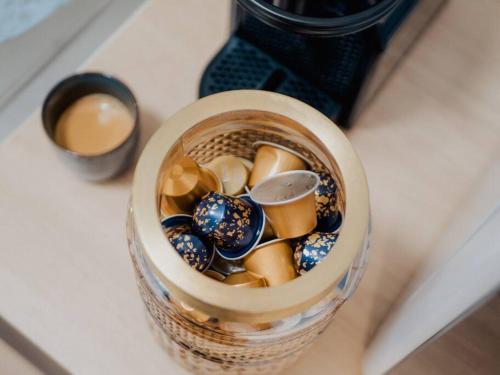 un bocal en verre rempli de porcelaine colorée posé sur un comptoir dans l'établissement L’Écrin Nîmes - Le Cocoon Dorée, à Nîmes