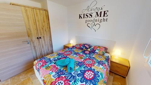 een slaapkamer met een bed en een bord aan de muur bij Lou Colibri in Le Thoronet