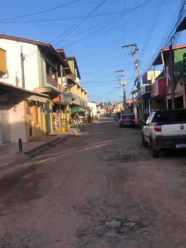 uma rua vazia numa cidade com carros estacionados em Casa e suítes da Vava em Trairi
