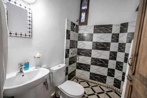 uma casa de banho com um WC branco e um lavatório. em Dar Fez Unique em Fez