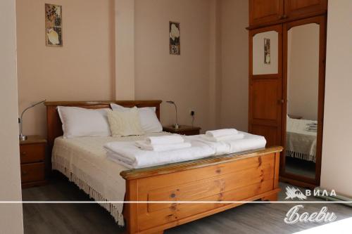 een slaapkamer met een bed, een dressoir en een spiegel bij ВИЛА БАЕВИ in Velingrad