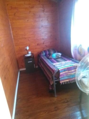 a small room with a couch in a wooden room at Morada de Campo in La Coronilla