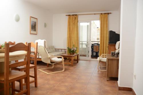 a living room with a table and chairs at Sa Marina in Cala Millor