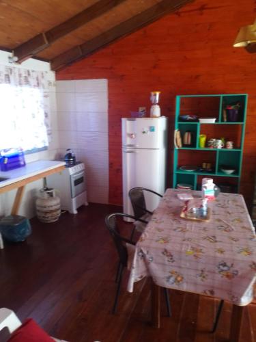 cocina con mesa y nevera blanca en Morada de Campo, en La Coronilla