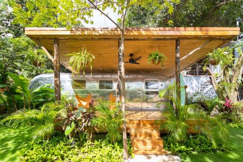a tiny house with a roof in a garden at Somos in Santa Teresa Beach
