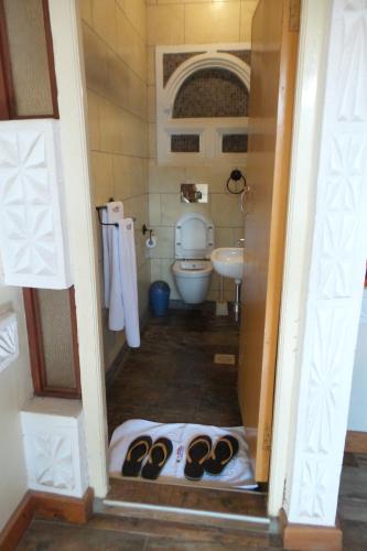 een badkamer met een toilet en een wastafel bij Parklands Shade Hotel in Nairobi