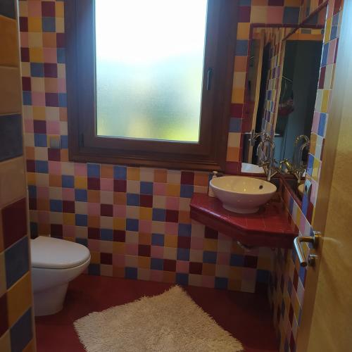 a bathroom with a toilet and a sink and a window at A de Bego in Mougás