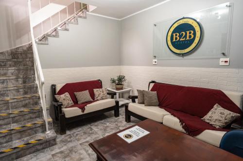a living room with two couches and a staircase at Hostel B2B SP in Sao Paulo