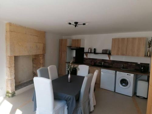 - une cuisine avec une table et des chaises blanches dans la chambre dans l'établissement Gîte 1921, à Vendeuvre