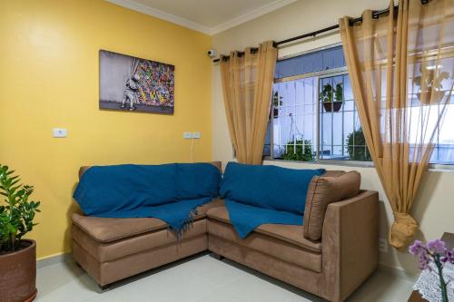 a living room with a couch and a window at Hostel B2B SP in Sao Paulo