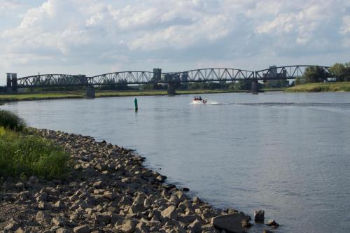 a boat on a river with a bridge in the background at "Ferienwohnung am Schloss" - Ferienwohnung mit Blick auf das Barbyer Schloss, 5 Gehminuten bis zur Elbe in Barby