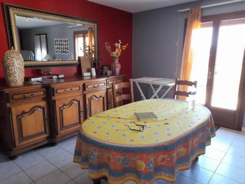 une salle à manger avec une table et un miroir dans l'établissement La belle maisonette, à Montmorillon
