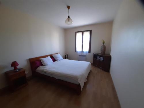 a bedroom with a bed and a window at La belle maisonette in Montmorillon
