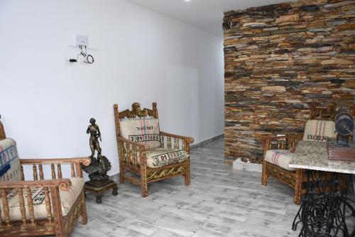 a living room with chairs and a brick wall at Paisa Territory Jardin in Jardin
