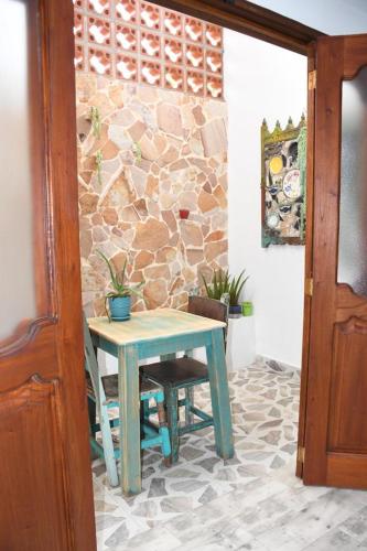 a blue table and chairs in a room with a stone wall at Paisa Territory Jardin in Jardin