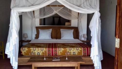 a bedroom with a bed with a canopy at Villa Moringa Lodge 
