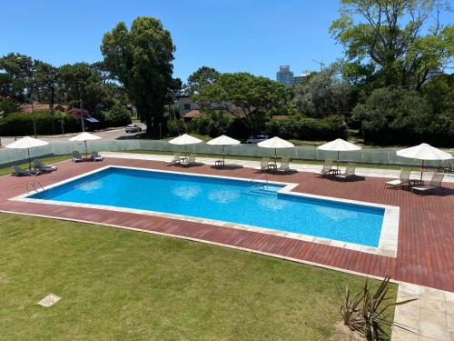 a large swimming pool with umbrellas and chairs at Miami Boulevard II excelente, a 100 metros del mar in Punta del Este