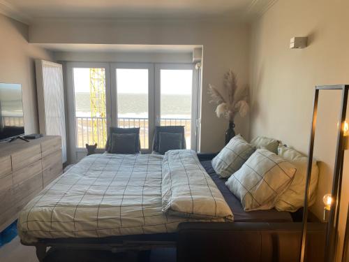 a bedroom with a bed with a view of the ocean at Casino Beach in Middelkerke