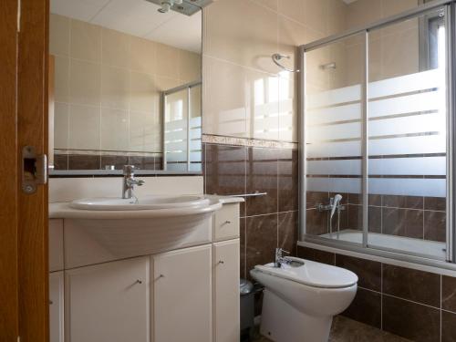a bathroom with a sink and a toilet and a mirror at Villa Victor in Riumar