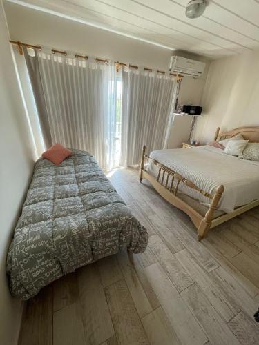 a bedroom with two beds and a large window at Departamento Tierras del Malbec in San Rafael