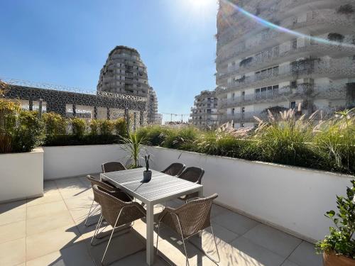 a table and chairs on a balcony with buildings at Duplex Rooftop d'exception terrasse panoramique de 100 m2 in Casablanca
