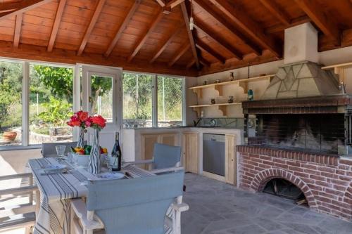 a kitchen with a fireplace and a table with flowers at Villa Rose Garden in Panormos Skopelos