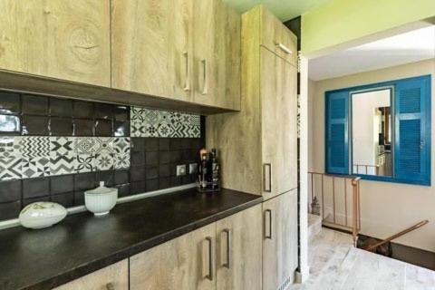 a kitchen with wooden cabinets and a mirror at Villa Rose Garden in Panormos Skopelos