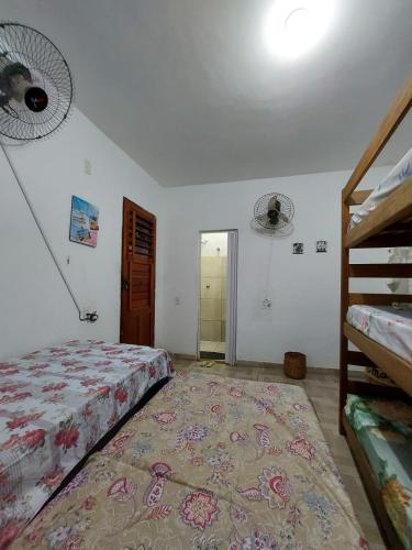 a bedroom with a bed and a rug on the floor at SUITE CENTRAL BECO DAS FLORES in Jericoacoara