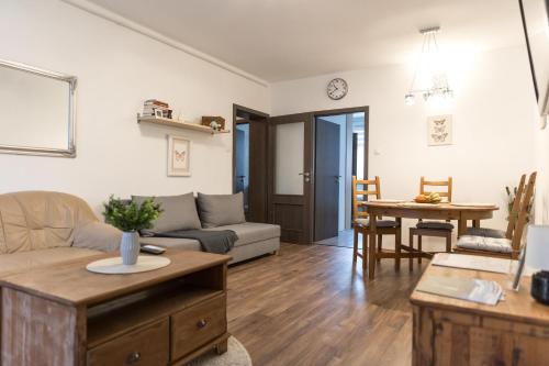 een woonkamer met een bank en een tafel bij Sflower Apartman in Eger
