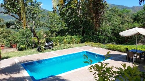 a swimming pool in a yard with a tennis court at Finca Salitre in Nimaima