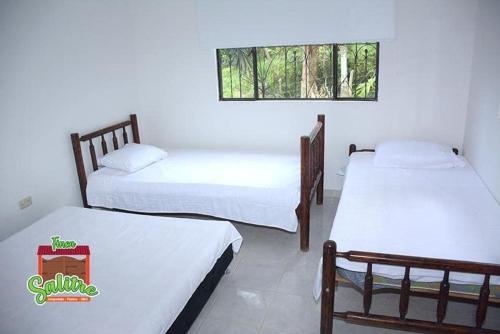 a room with two beds and a window at Finca Salitre in Nimaima